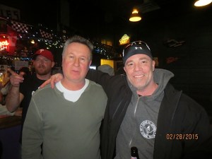 Stevo, getting tired of posing for his 300th photo an a happy junior posing with his boyhood idol.  However, Doc tries to tell the photographer there is something more interesting occurring behind him.